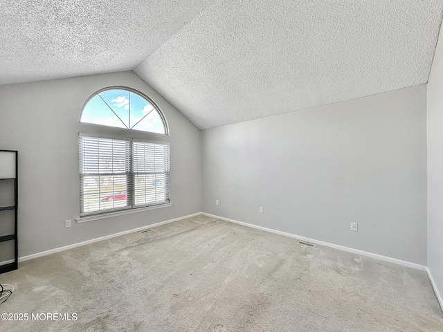 carpeted empty room with lofted ceiling and a textured ceiling