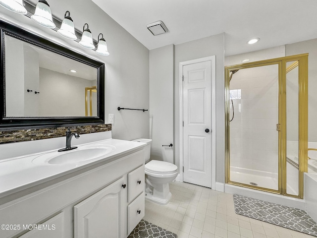 bathroom featuring vanity, a shower with shower door, tile patterned floors, and toilet