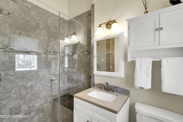 bathroom featuring vanity, an enclosed shower, and toilet