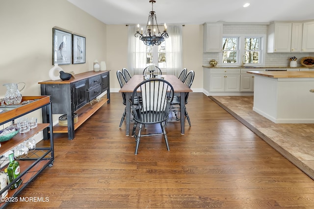 dining area featuring an inviting chandelier, sink, hardwood / wood-style floors, and a wealth of natural light