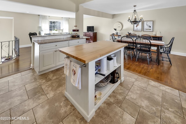 kitchen with white cabinetry, wood counters, a kitchen island, and hanging light fixtures