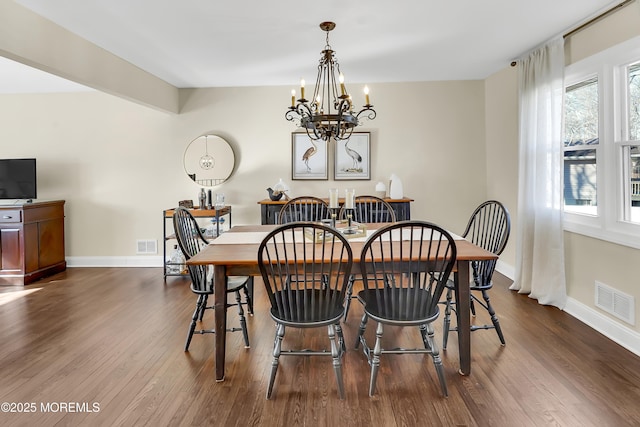 dining room with an inviting chandelier and dark wood-type flooring