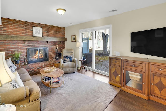 living room featuring dark wood-type flooring and a fireplace