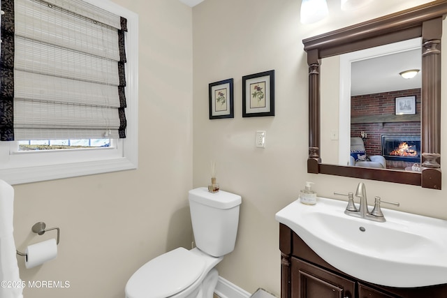 bathroom with vanity, a fireplace, and toilet