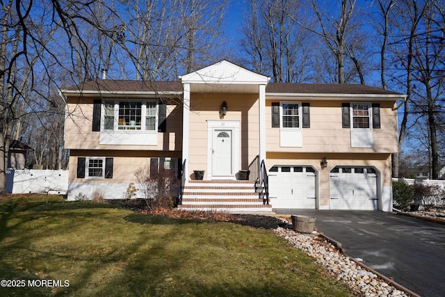 split foyer home with a garage and a front yard