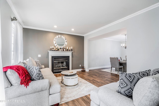 living room with hardwood / wood-style flooring, ornamental molding, and an inviting chandelier