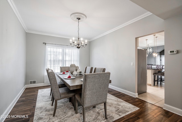 dining space featuring an inviting chandelier, wood-type flooring, and ornamental molding