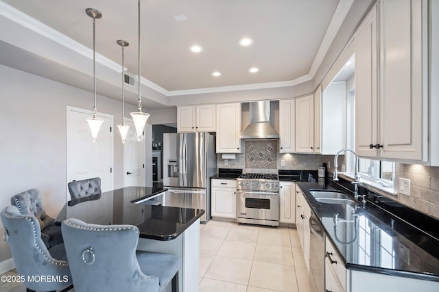 kitchen with wall chimney exhaust hood, sink, white cabinetry, a kitchen breakfast bar, and stainless steel appliances