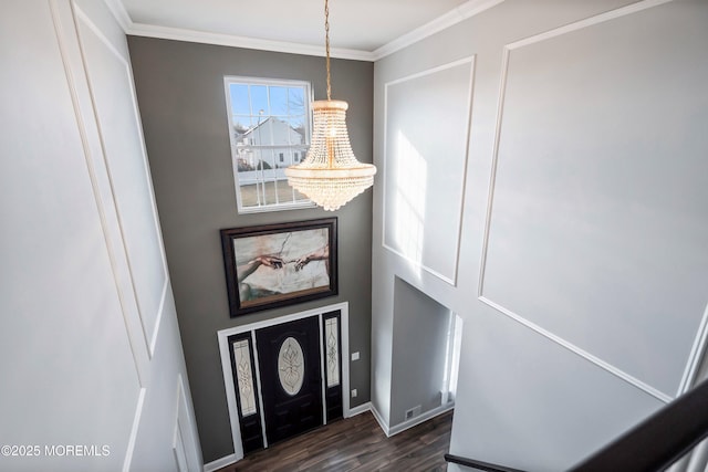 foyer entrance featuring ornamental molding, dark hardwood / wood-style floors, and a chandelier