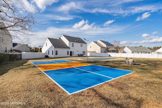 view of sport court with tennis court and a lawn