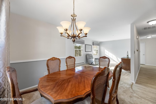 dining area featuring light wood-type flooring, a chandelier, and baseboard heating