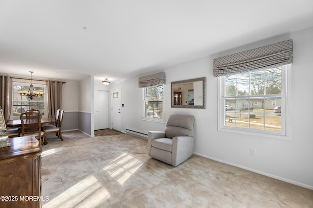 sitting room featuring a wealth of natural light, light colored carpet, a notable chandelier, and baseboard heating