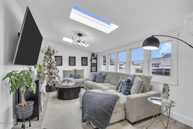 living room featuring hardwood / wood-style floors, plenty of natural light, and vaulted ceiling with skylight