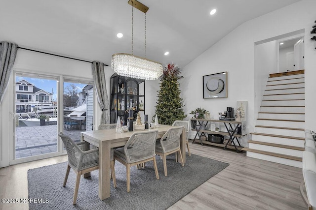 dining room featuring vaulted ceiling and light hardwood / wood-style flooring