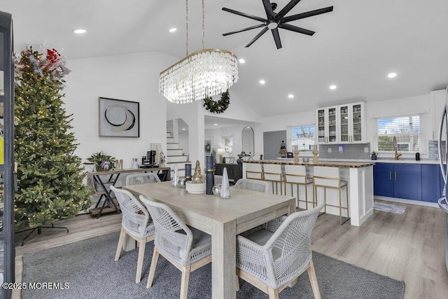 dining area featuring lofted ceiling, a notable chandelier, and light hardwood / wood-style floors