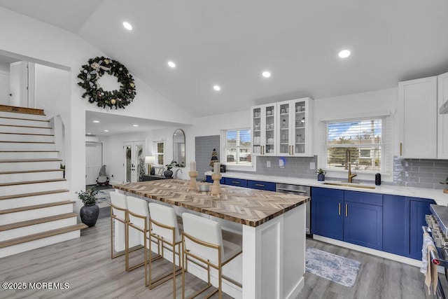 kitchen featuring sink, a breakfast bar, blue cabinets, white cabinets, and a kitchen island