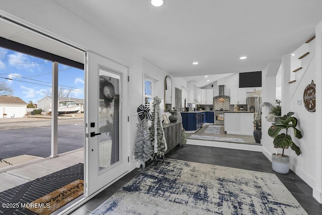 entryway with dark tile patterned floors and lofted ceiling