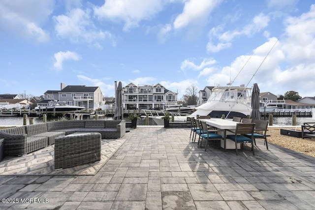 view of patio / terrace with a water view, outdoor lounge area, and a boat dock