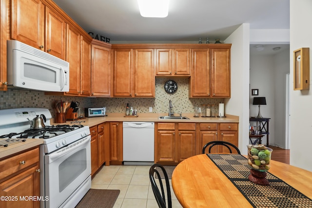 kitchen featuring white appliances, sink, decorative backsplash, and light tile patterned floors