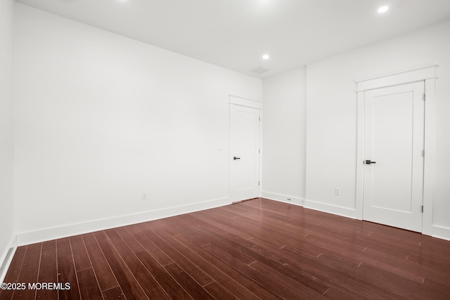 empty room with dark hardwood / wood-style flooring