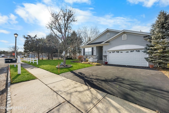 ranch-style home featuring a garage and a front lawn