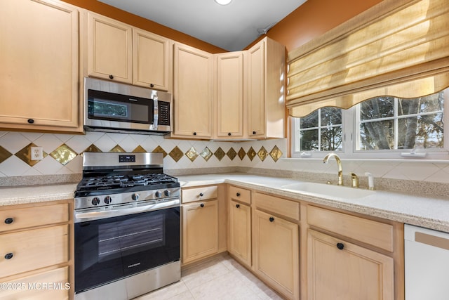 kitchen with backsplash, appliances with stainless steel finishes, sink, and light brown cabinets