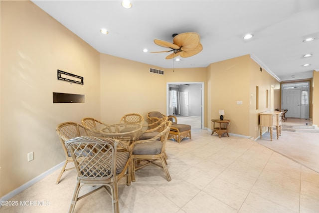 tiled dining space with crown molding and ceiling fan