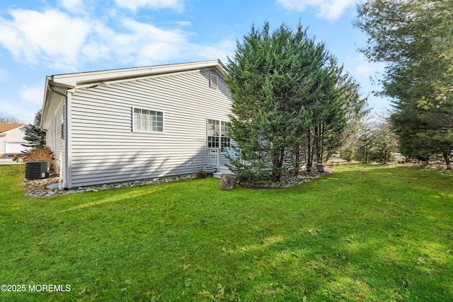 view of side of property with a lawn and central air condition unit