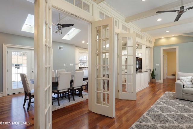 living room featuring a wealth of natural light, a skylight, and dark hardwood / wood-style floors