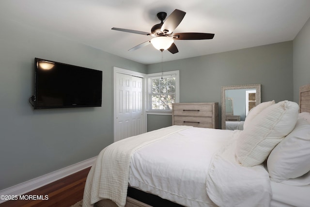 bedroom with dark wood-type flooring, a closet, and ceiling fan