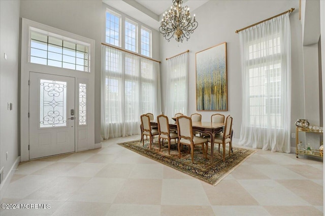 dining space with a high ceiling and a notable chandelier