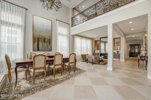 dining space featuring an inviting chandelier and a high ceiling