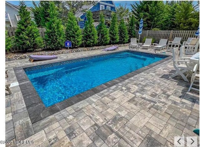 view of swimming pool with fence, a fenced in pool, and a patio