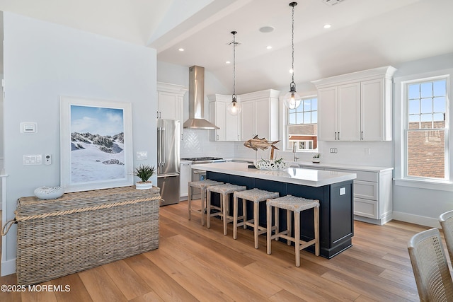 324 3rd St, Beach Haven, NJ 08008 - kitchen with wall chimney range hood, stainless steel appliances, a kitchen island, light wood-style floors, and recessed lighting