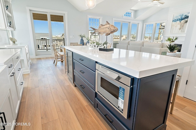 324 3rd St, Beach Haven, NJ 08008 - kitchen with vaulted ceiling, light wood finished floors, ceiling fan, white cabinetry, and light countertops