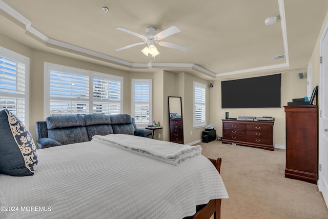 carpeted bedroom with a raised ceiling, crown molding, and ceiling fan