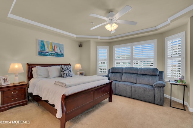 carpeted bedroom featuring ceiling fan, ornamental molding, and a raised ceiling