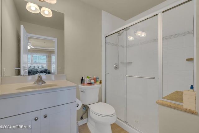 bathroom featuring vanity, an enclosed shower, and toilet