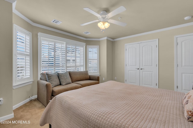 carpeted bedroom featuring ornamental molding, a closet, and ceiling fan