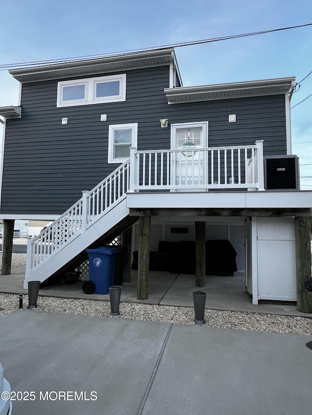 rear view of property featuring a deck and a patio area