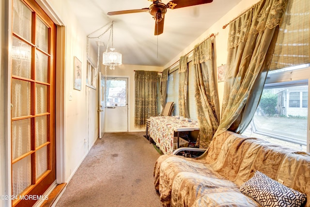 sitting room with ceiling fan with notable chandelier and carpet floors