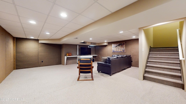 carpeted living room with a paneled ceiling