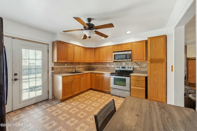 kitchen with sink, backsplash, stainless steel appliances, and ceiling fan