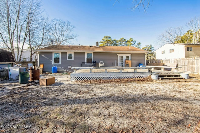 back of house featuring a wooden deck and french doors