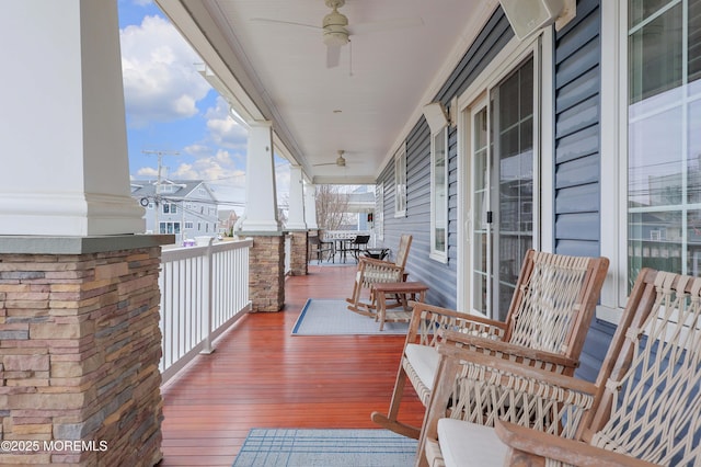 wooden terrace with ceiling fan and covered porch