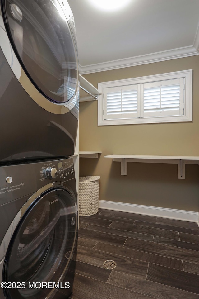 clothes washing area featuring ornamental molding and stacked washer and clothes dryer