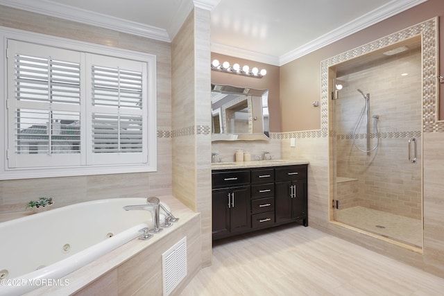 bathroom with tile walls, vanity, crown molding, and separate shower and tub