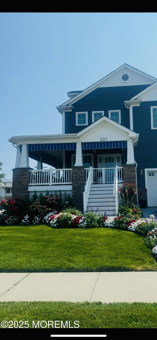 view of front of house featuring covered porch and a front lawn