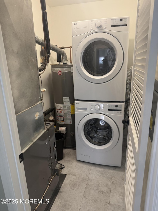 washroom with stacked washer / dryer, water heater, and light tile patterned floors