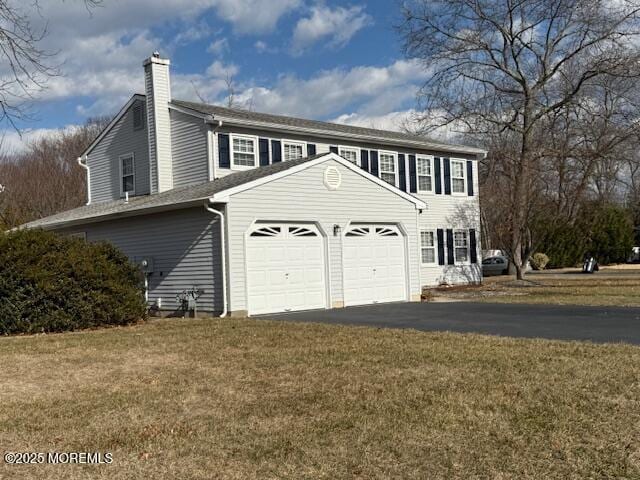 view of home's exterior with a garage and a lawn